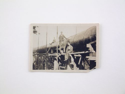 View of four men posing by a pipeline under construction, unknown location