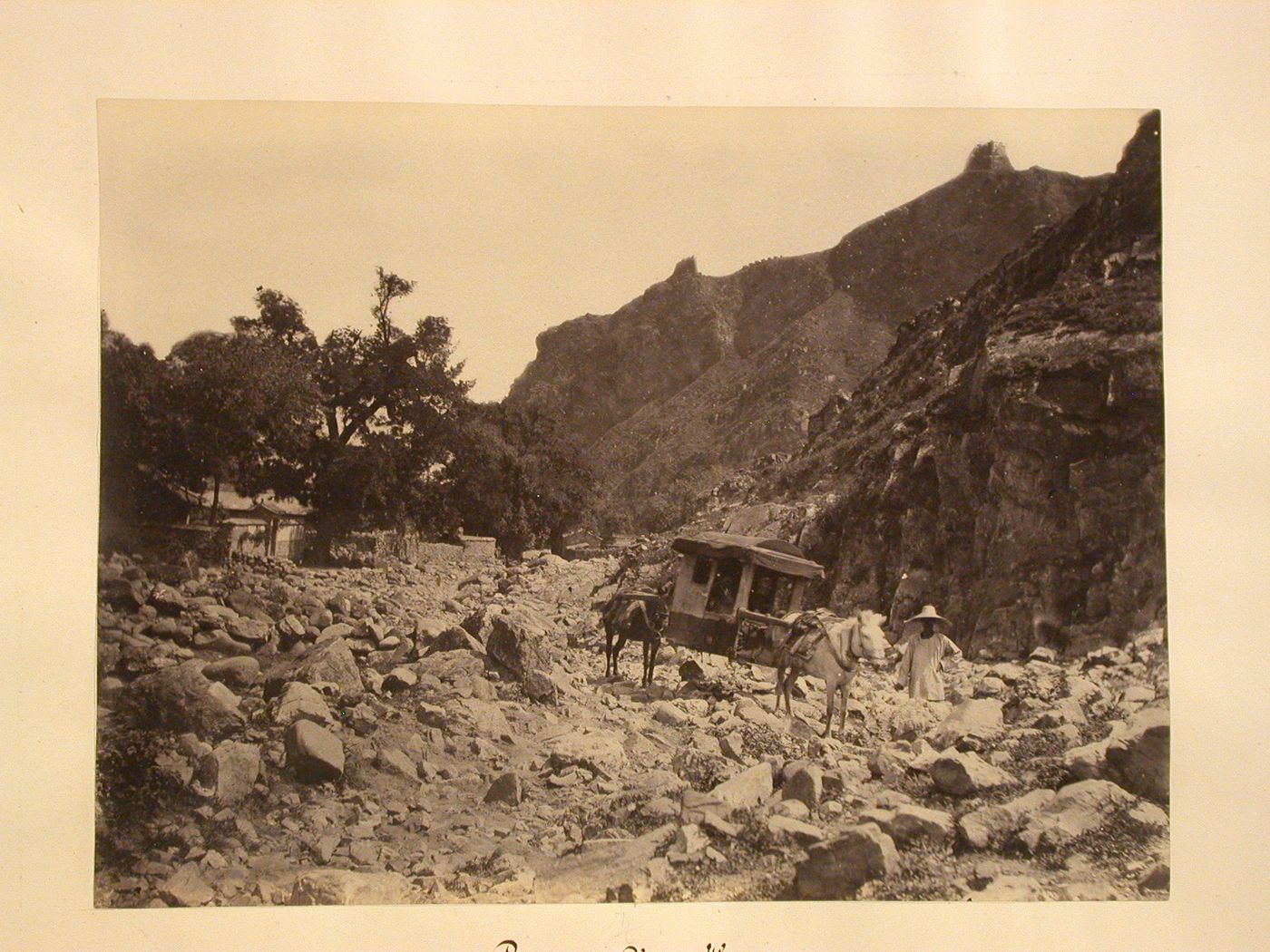 Lateral view of a mule litter with a village in the background and the Great Wall ? on the mountains to the right, Nankow (now Nankou) ?, Changping County ?, Peking (now Beijing), China