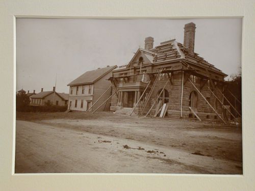 Front view of stone and wood house with scaffolding up to roof