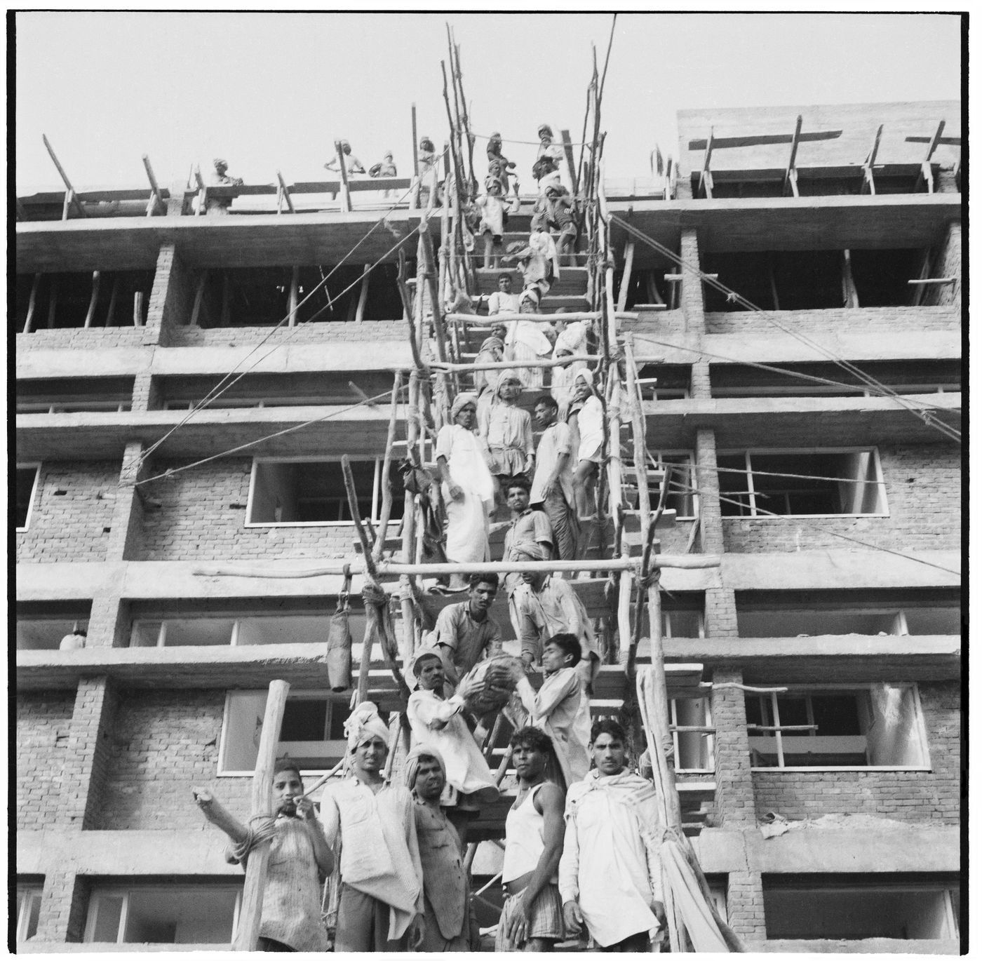 Workers form a human chain for pouring concrete manually at a building site in Chandigarh, India