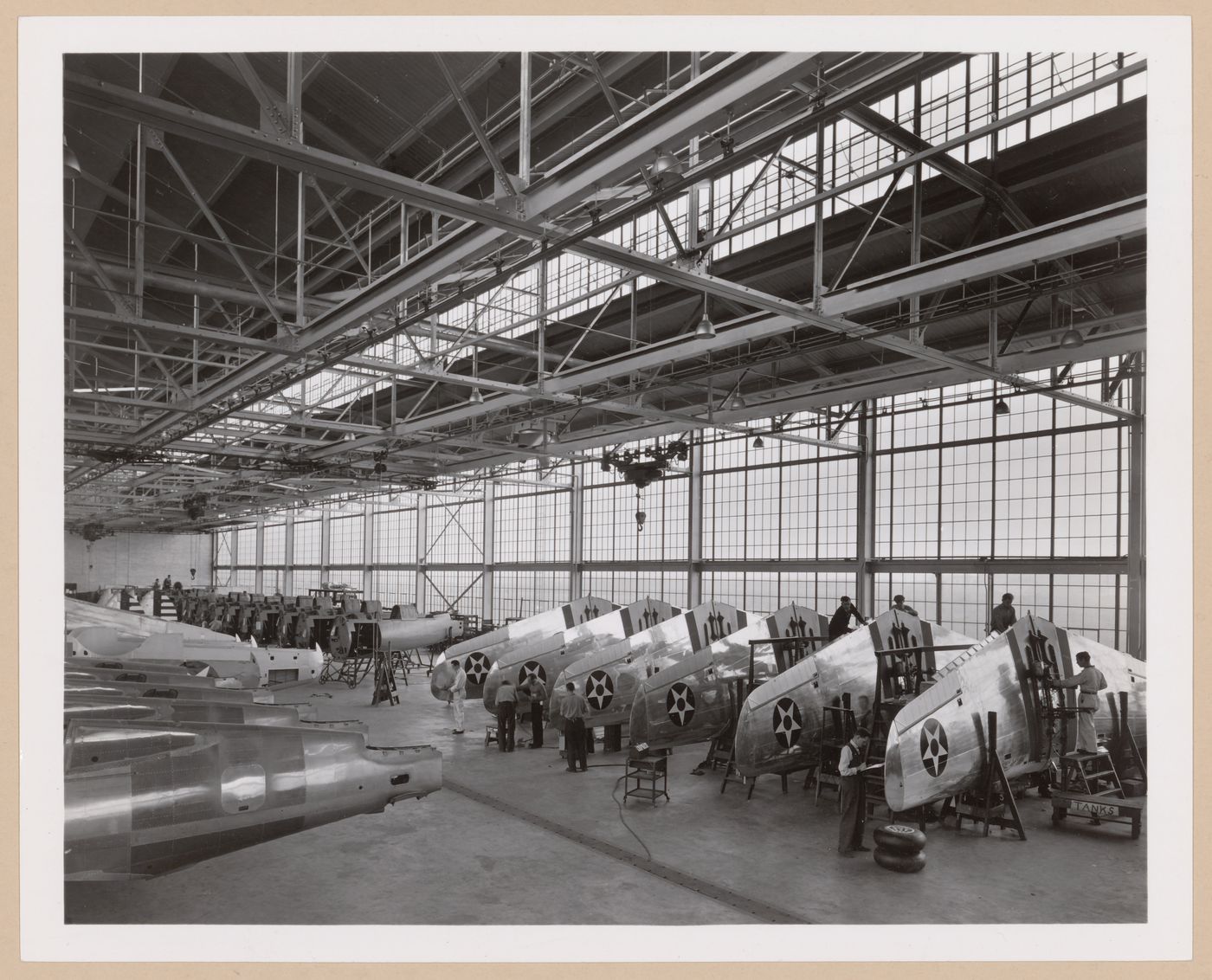 Interior view of the Assembly Building showing workers assembling airplanes, Curtiss-Wright Corporation Airplane division Assembly Plant, Buffalo, New York