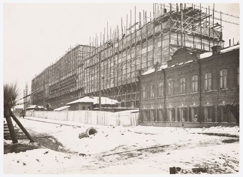 View of the Building of Industry construction site with a two-storey brick building in the foreground, Sverdlovsk, Soviet Union (now Ekaterinburg, Russia)