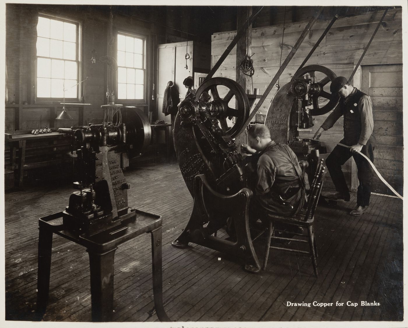 Interior view of workers drawing copper for cap blanks at the Energite Explosives Plant No. 3, the Shell Loading Plant, Renfrew, Ontario, Canada