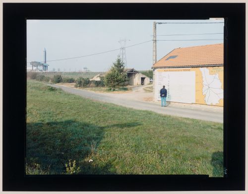 View of a building with a billboard map on the wall showing a service station in the background, Poitiers, France (from the series "In between cities")