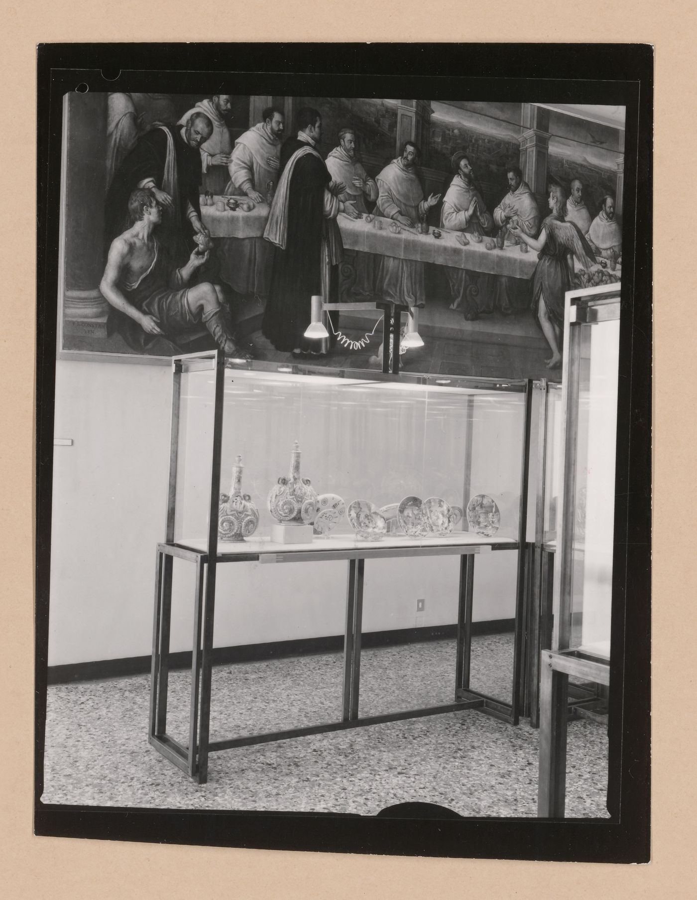 Interior view of a gallery showing a partial view of a painting of the Last Supper with a display case containing painted dishes in the foreground, Museo Correr, Venice, Italy