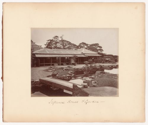 View of a mansion and garden showing a pond and a stone footbridge, Japan