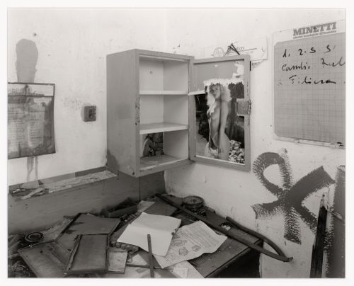 Partial view of a room showing a desk, cupboard, posters and papers, Malteria Adriatica, Marghera, Italy