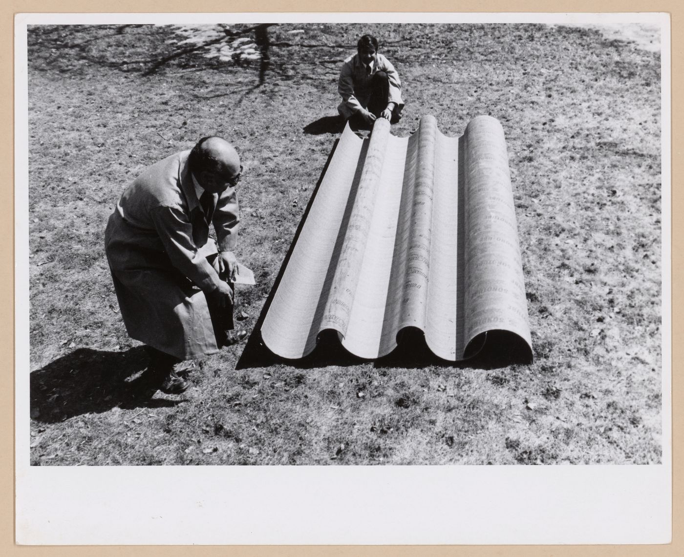 Two member of Minimum Cost Housing Group and a piece of the roofing of Ecol House