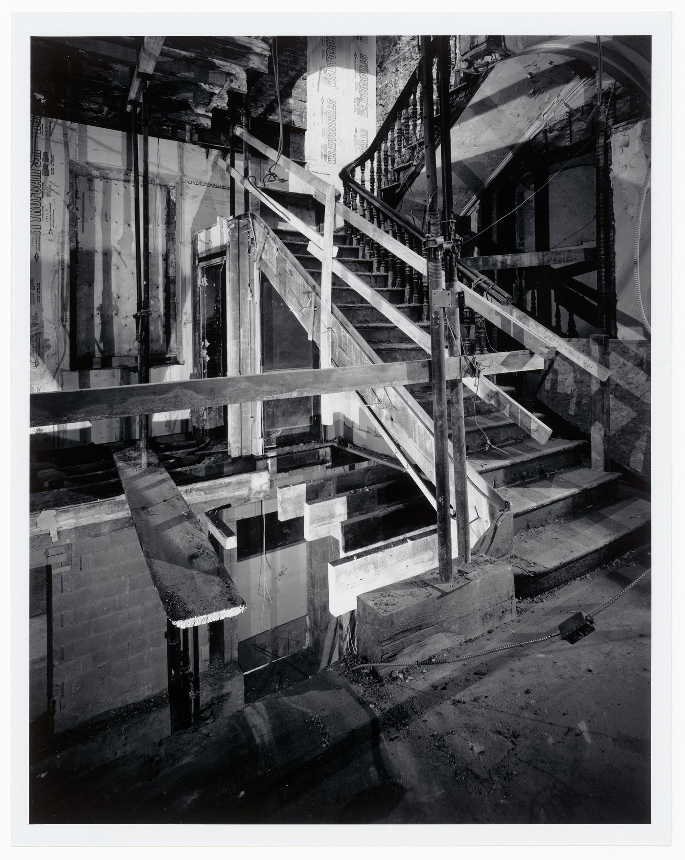 Interior view of the original carved wooden stairs surrounded by temporary construction framework, Shaughnessy House under renovation, Montréal, Québec