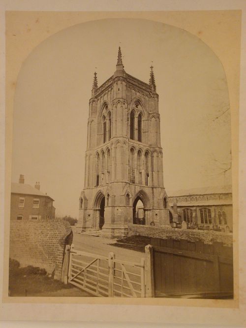View of a church taken from behind the churchyard gate showing a tower, the nave and the cemetery, England