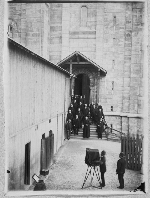 View of Louis-Émile Durandelle directing portrait session of Francois Richard, the architects Henri Rauline and Charles Laisne, Hubert Rohault de Fleury, Father Francois Voirin, and the Comite du Voeu national outside Basilica of Sacré-Coeur de Montmartre, Paris, France