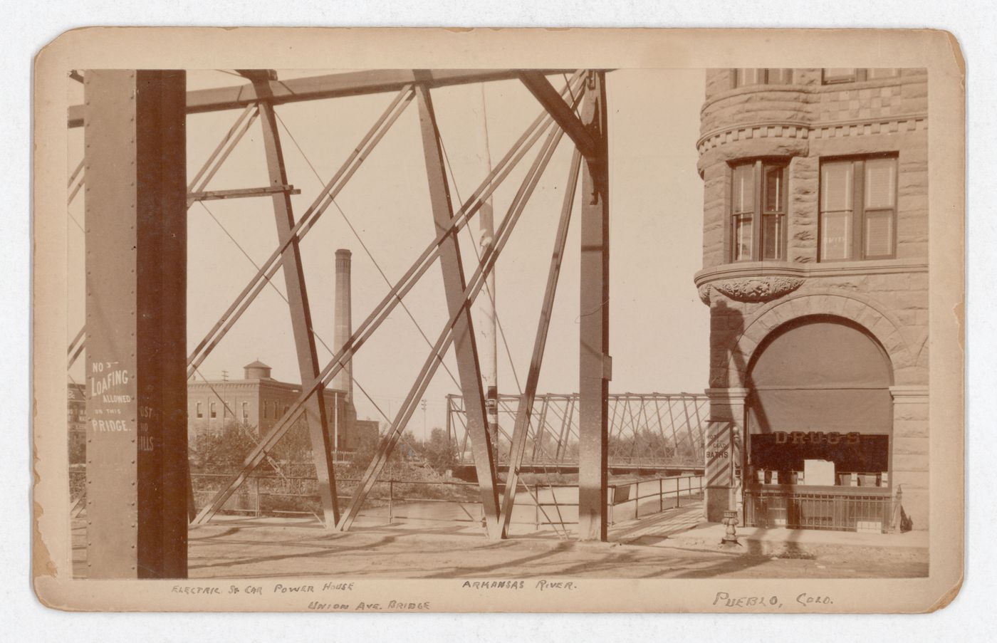Partial view of Union Avenue Bridge (now demolished) and Arkansas River, with electric streetcar powerhouse in the left background, Pueblo, Colorado, United States