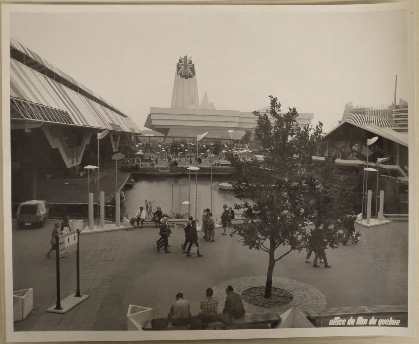 Partial view of a walkway and a waterway near the Pavilion of Trinidad & Tobago, and Grenada with the Great Britain Pavilion in background, Expo 67, Montréal, Québec