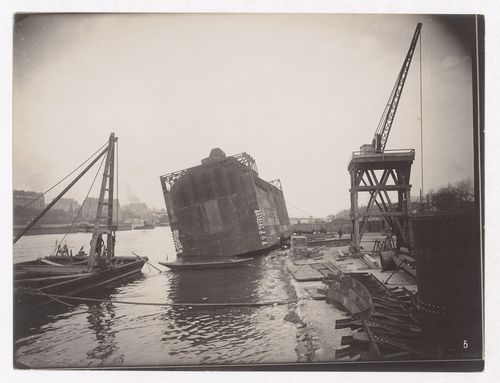 Construction of the Paris Metro, exterior view of a caisson, workers and the Seine, Paris, France