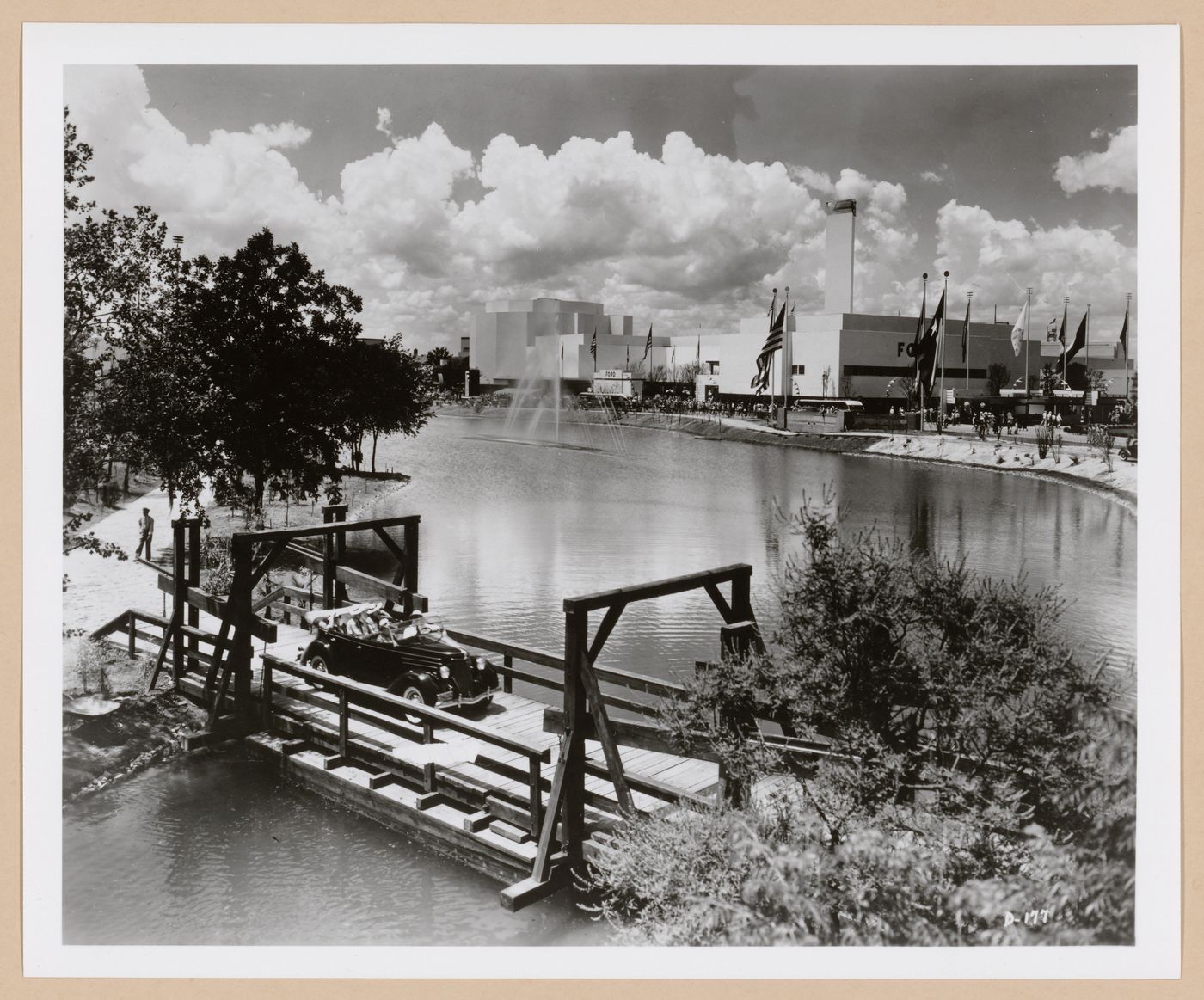 View of the Ford Motor Company pavilion from across a river showing an automobile and fountain, 1939-1940 New York World's Fair, New York City, New York