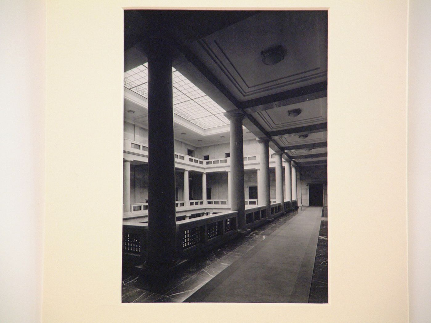 Interior of large building with multi-storied inner courtyard, roofed with glass
