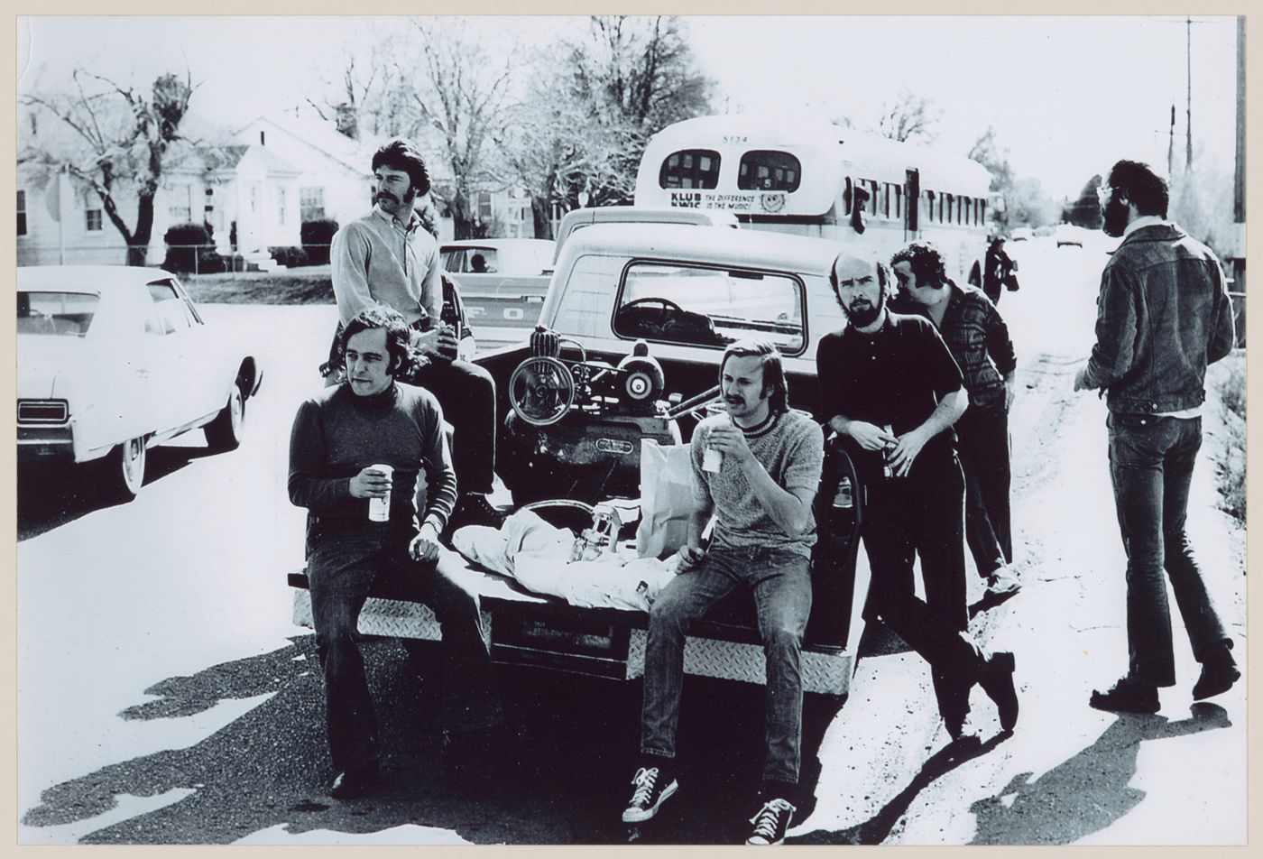 Photograph showing Pettena's team standing around a truck loaded with a paint sprayer and compressor for the Red Line project