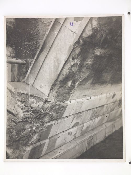 View of damage to the base of a stone arch bridge over water, United Kingdom