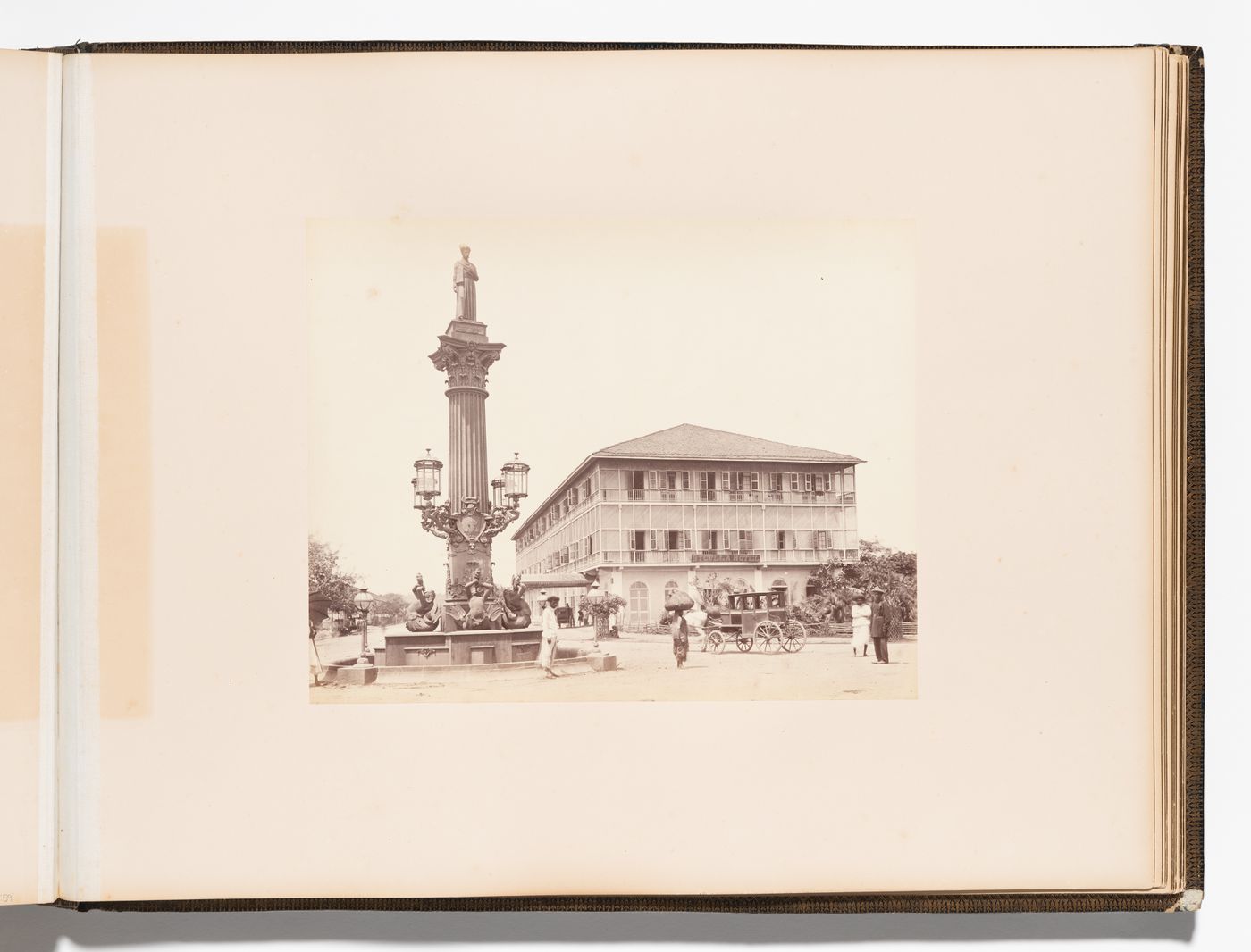 View of a column with the Statue of Cursetji Manekji (also known as the Khada Parsi) on top showing the Byculla Hotel in the background, Bombay (now Mumbai), India