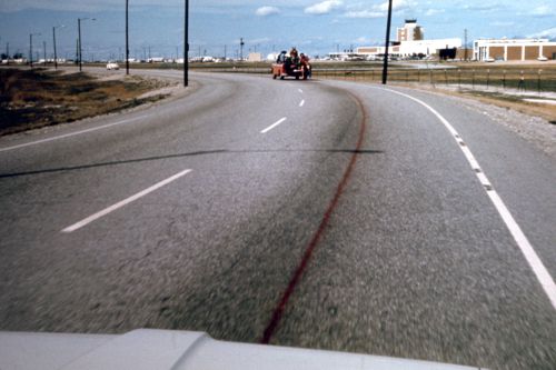 Photograph of truck spraying red paint on road during performance for Red Line