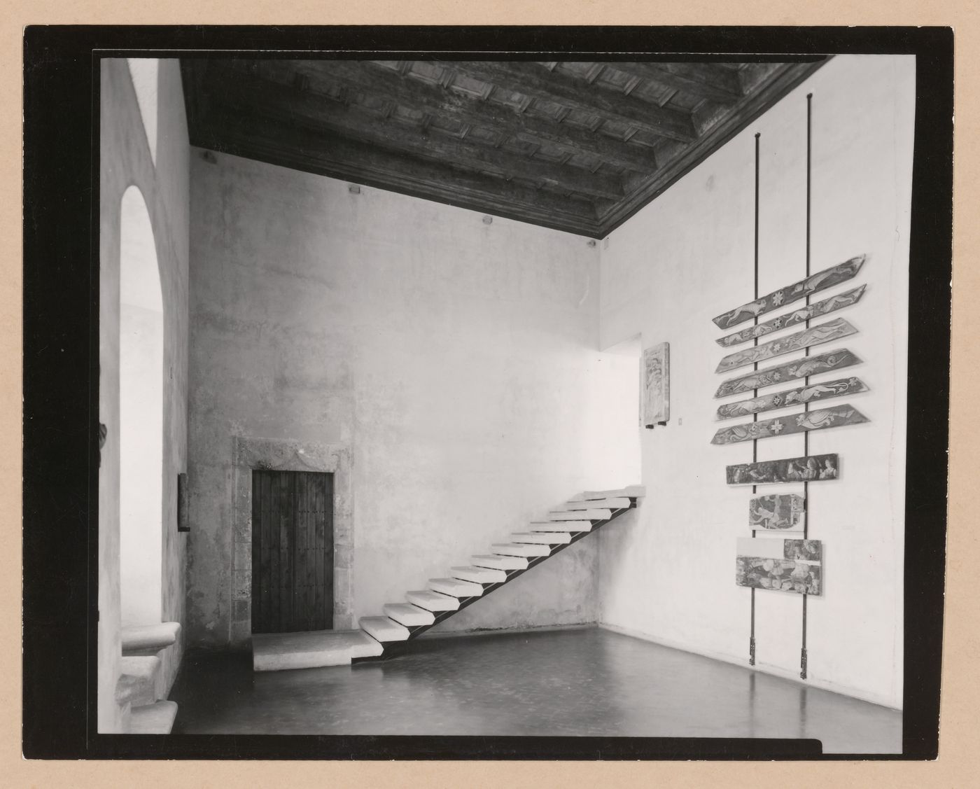 Interior view of Sala VI showing a door, staircase, paintings and a relief, Palazzo Abatellis, Galleria regionale della Sicilia, Palermo, Italy