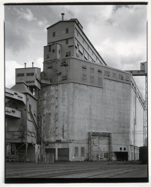 View of the east and north façades of Grain Elevator No. 1 (now demolished) showing the cupola, conveyor galleries and railway tracks, Port of Montréal, Québec