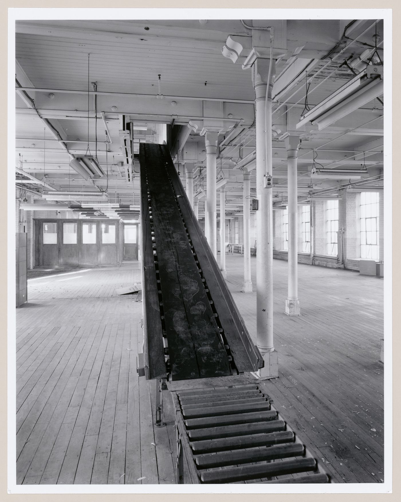 Interior view of workshops on the third floor of the Belding Corticelli Spinning Mill showing a conveyor, Montréal, Québec