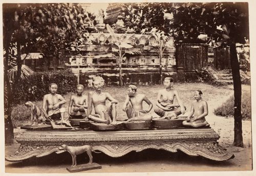 View of statues on and beside a platform with a temple [?] in the background, Burma (now Myanmar)