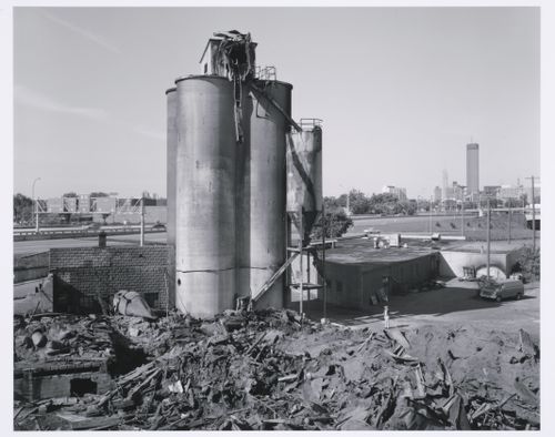 Man looking at pile of rubble next to standing elevators, Minneapolis, Minnesota