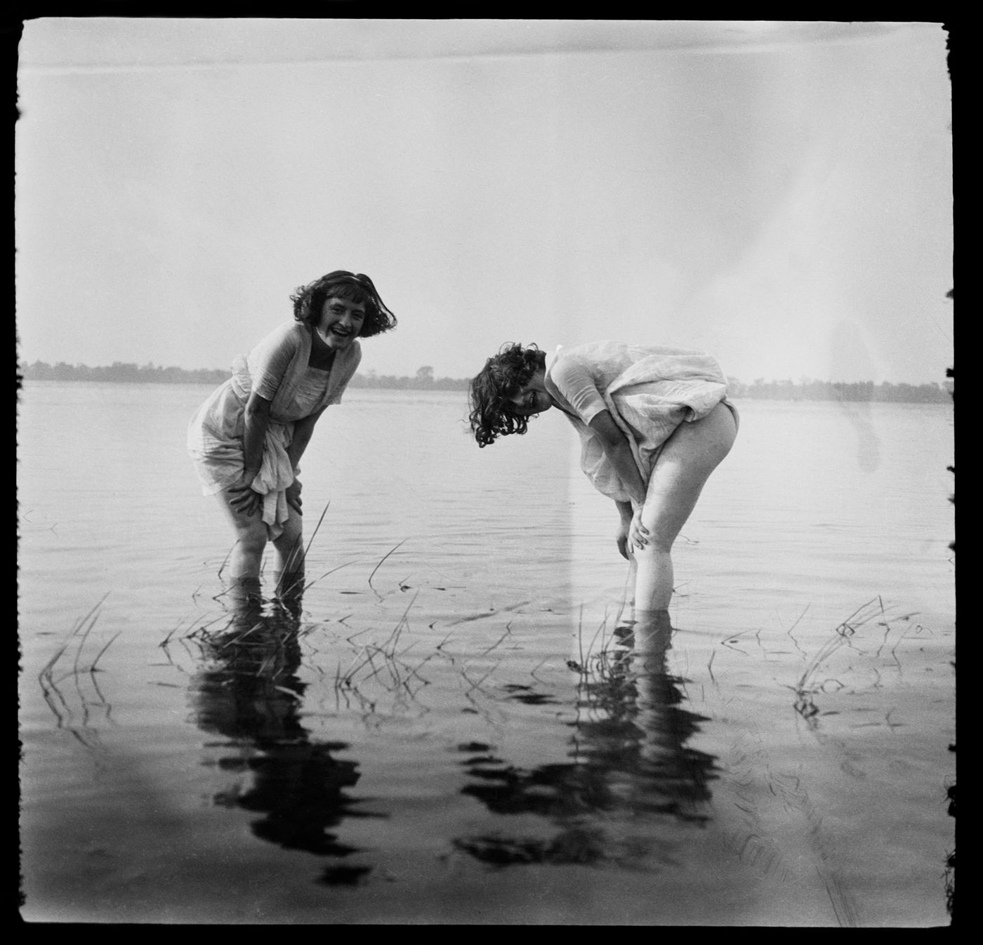 Portrait de deux femmes non identifiées, possiblement Clorinthe et Cécile Perron, près de la rive d'une étendue d'eau