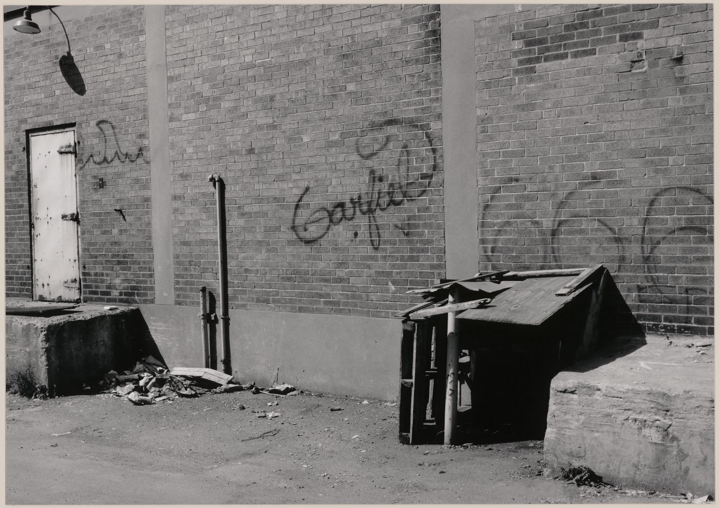 Field Work in Montreal: View of a shack-like structure of wood, metal and concrete, a brick wall and graffiti, Montréal, Québec