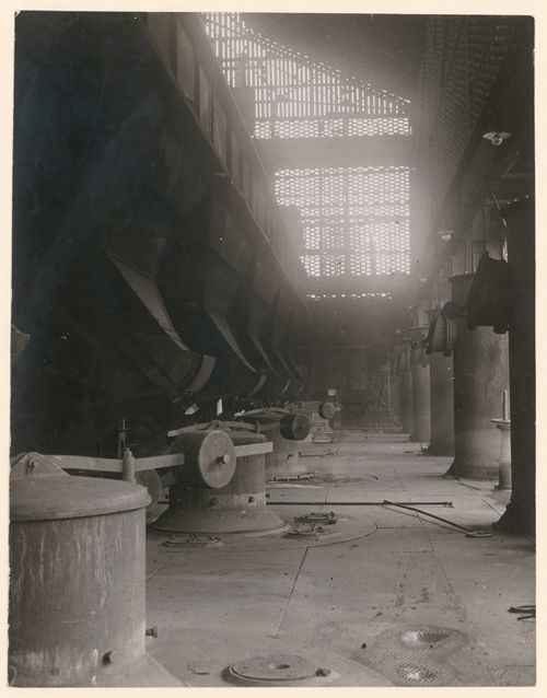 Interior of unidentified deserted industrial space, with a haze of light entering through grille at center