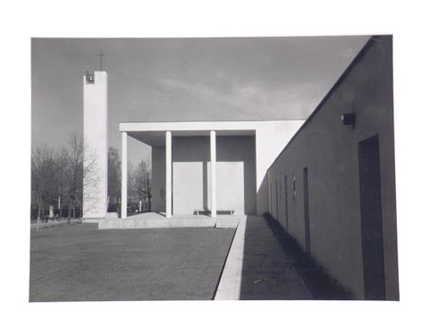 Exterior view of a modern church, with concrete clad bell tower surmounted by a cross, Germany
