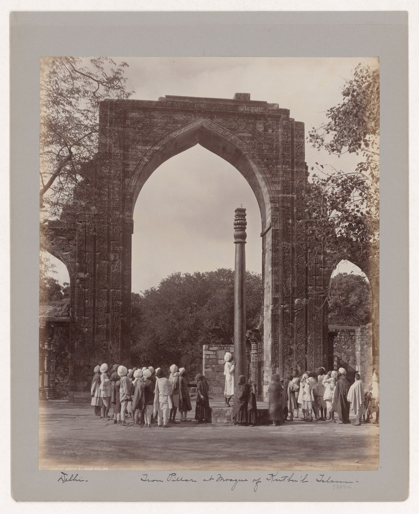 View of the arched screen façade of the Quwwat al-Islam [Might of Islam] Mosque and the Iron Pillar, Quwwat al-Islam Mosque Complex, Delhi, India