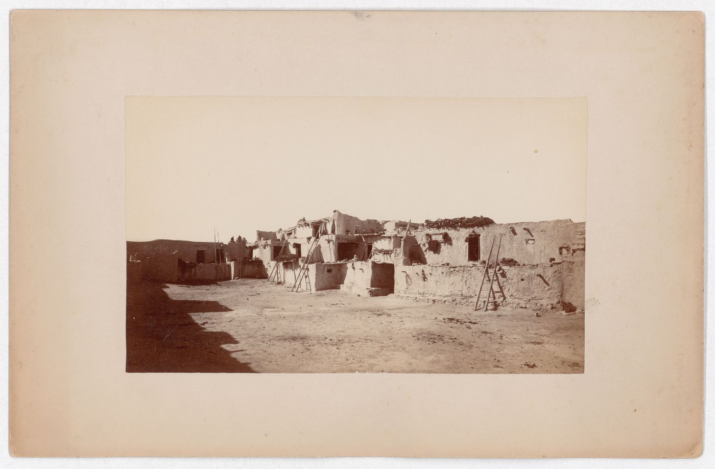 View of multi-storied terraced houses from a courtyard showing ladders and entrances, possibly Arizona, United States