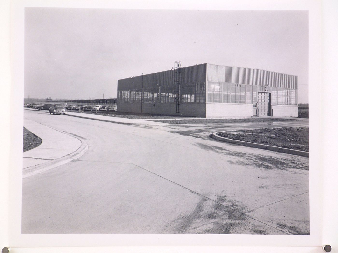 View of the principal and lateral façades of the Garage [?] with a parking lot on the left, Ford Motor Company Automobile Assembly Plant, Hamburg, New York