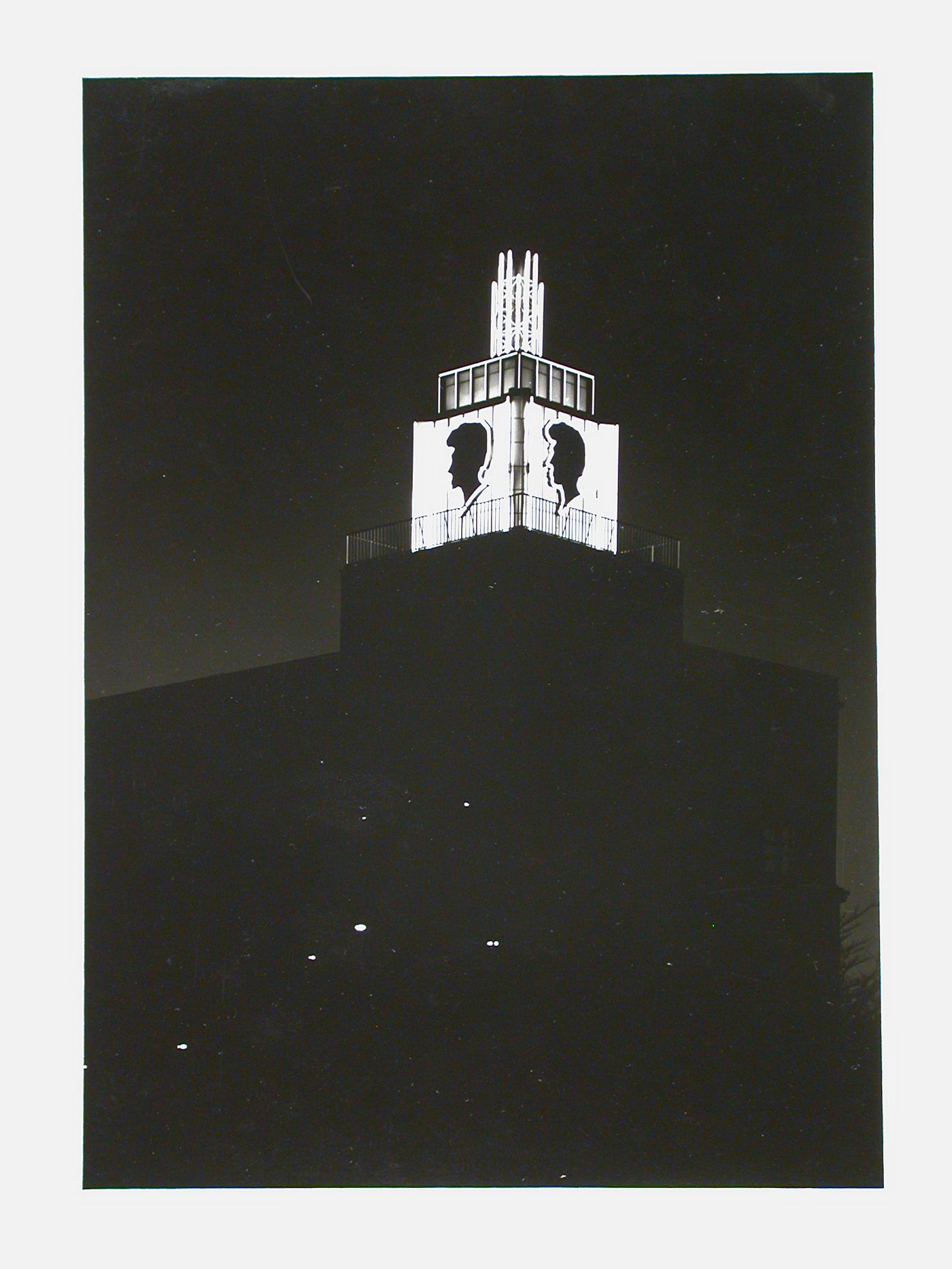 Night view of illuminated tower with profile silhouette on two sides of tower, Berlin, Germany
