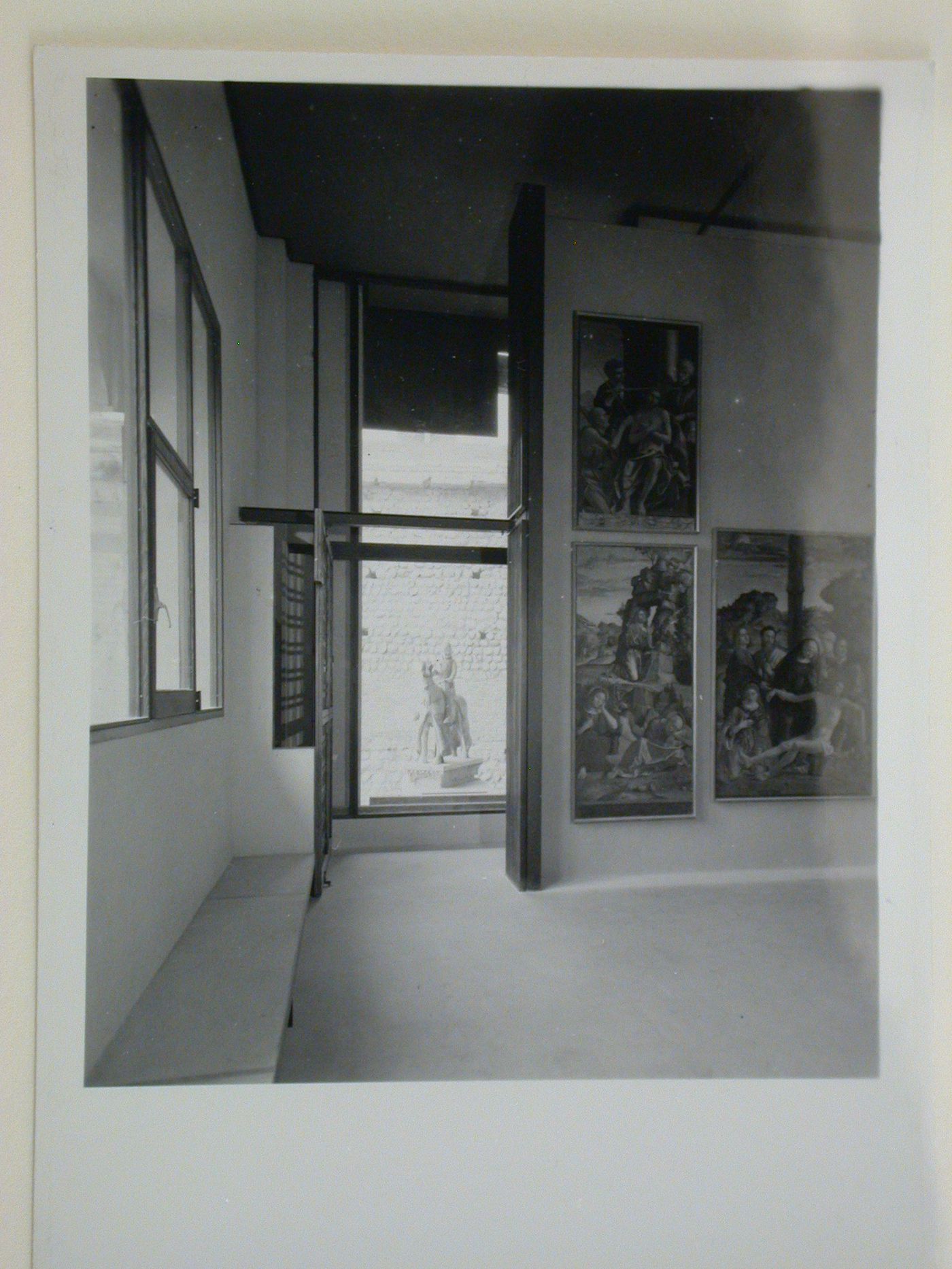 Interior view of a gallery showing paintings with the Can Grande della Scala Statue in the background, Museo di Castelvecchio, Verona, Italy