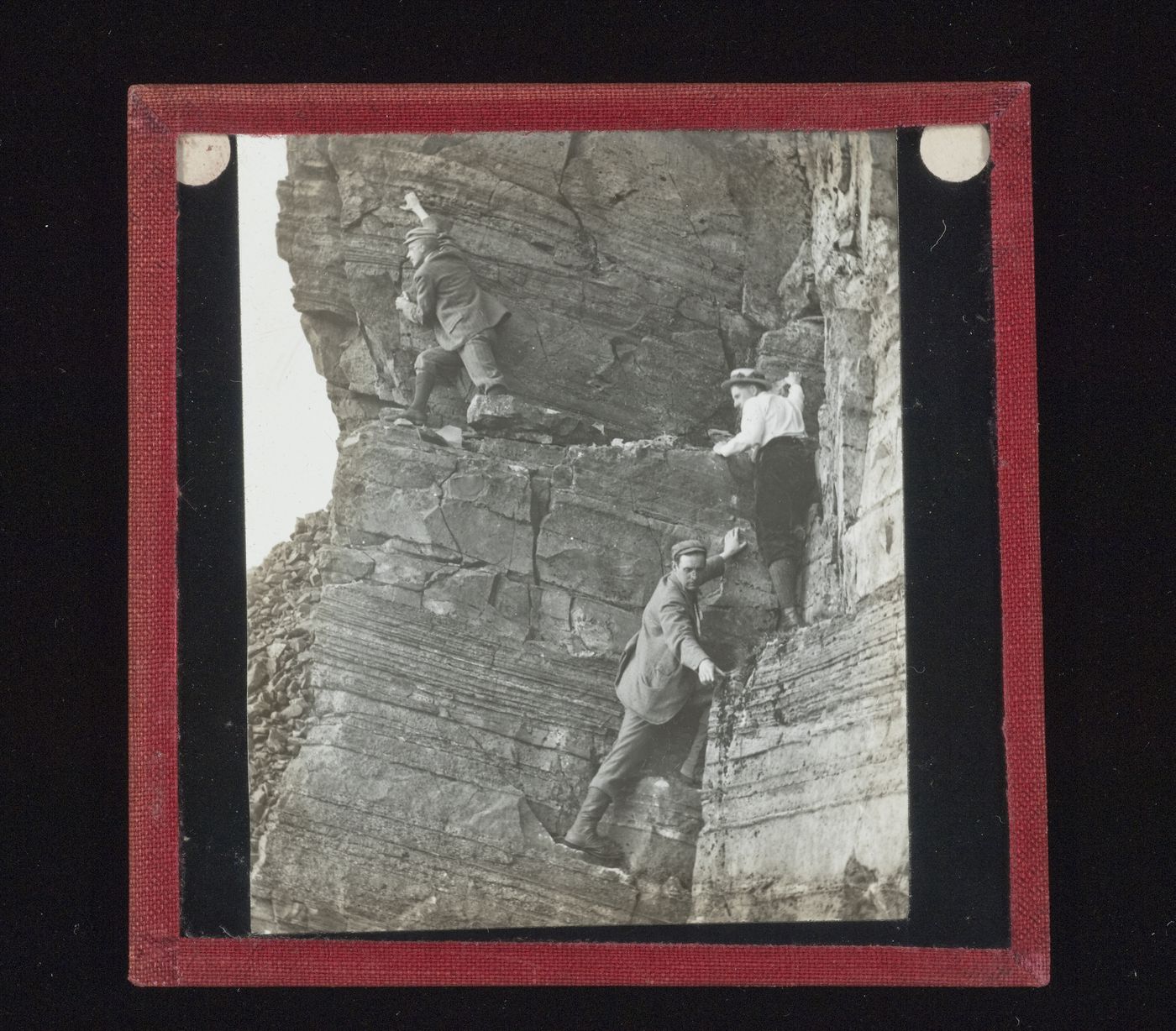 View of three unidentified men climbing