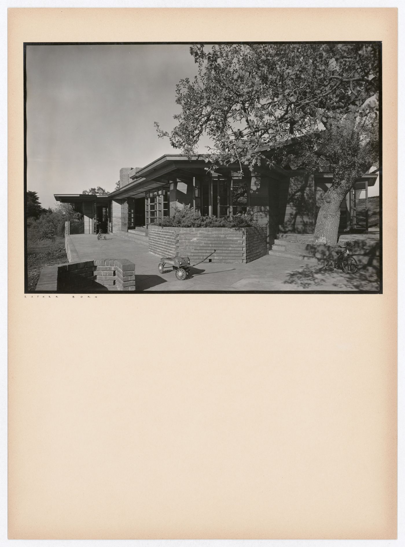 View of the Hanna House showing a terrace, entrances, a tree, a toy wagon, and  two tricycles, Palo Alto, California, United States

