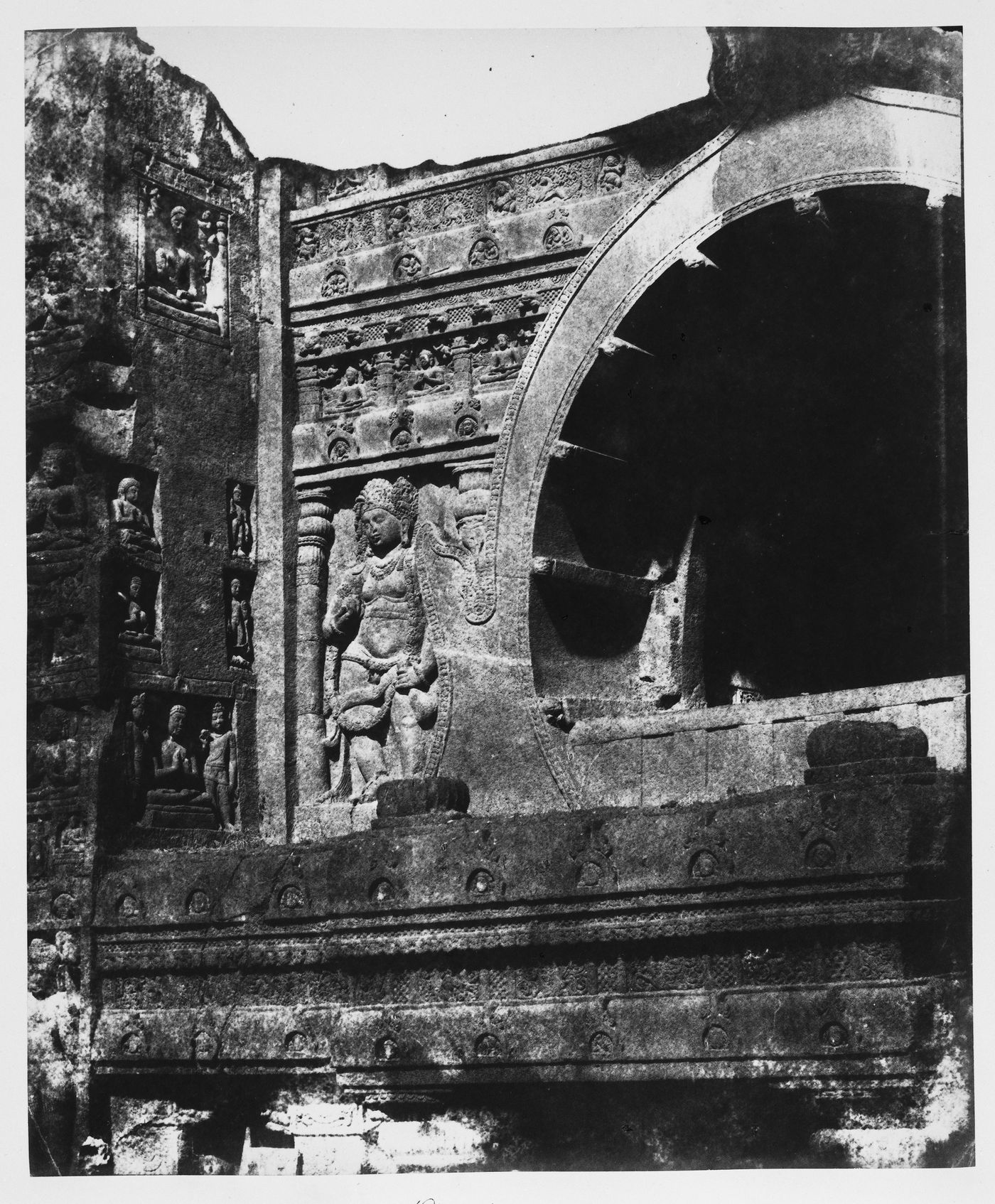 Partial view of the upper part of the entrance façade of Cave 19 showing the arch and bas-reliefs, Ajanta, India