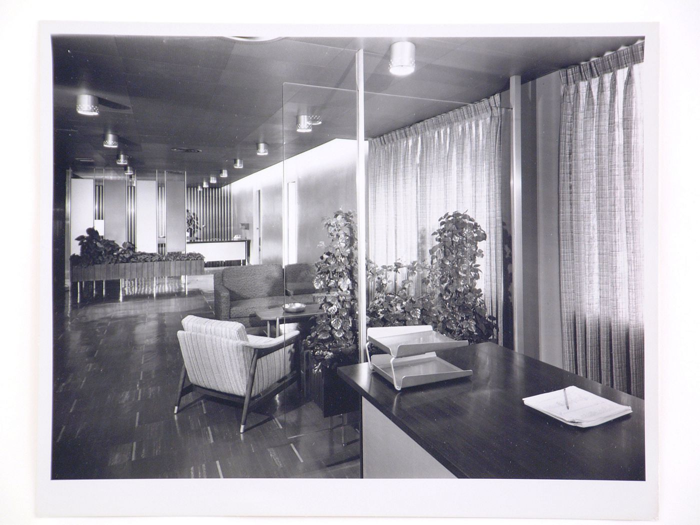 Interior view of an office in the Kaiser Center office building showing a chair, a sofa, desks and screens, Oakland, California