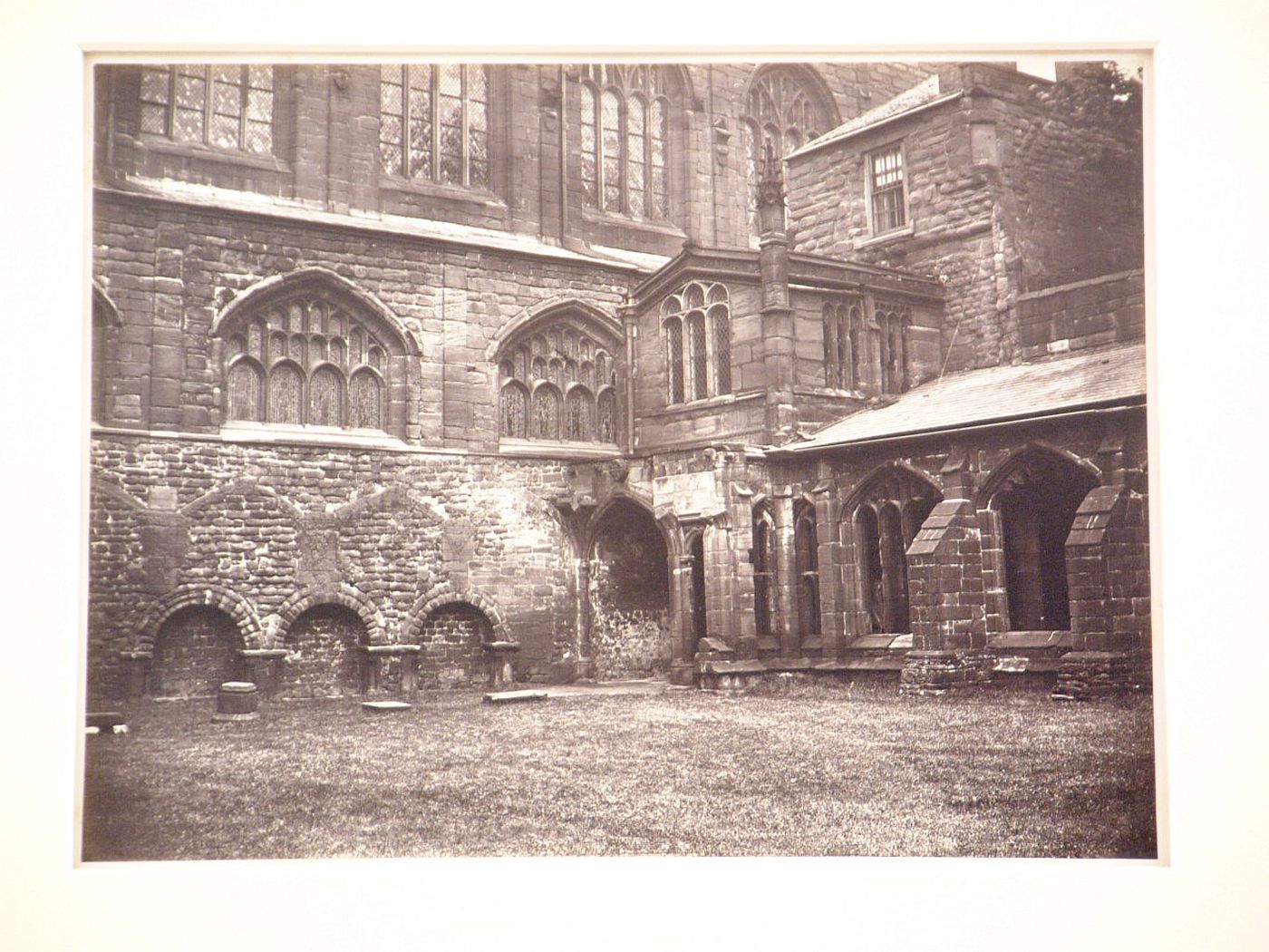 View of exterior of nave of church and entrance to cloisters from within the cloisters, Chester, England