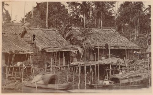 View of houses beside a river, probably in Cochin China (now in Vietnam)