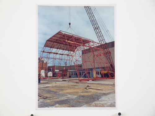 View of crane lifting a red metal structure