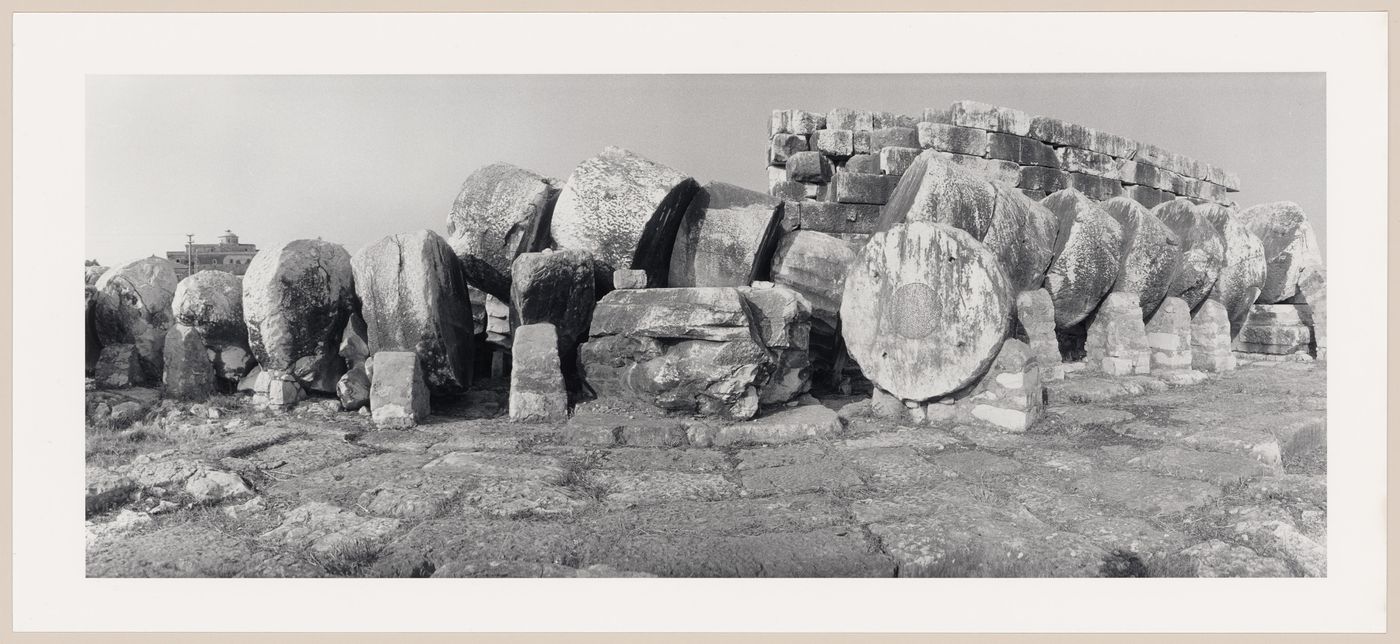 Panoramic view of circular stones from a toppled column with a building in the left background, Temple of Apollo, Didyma, Turkey