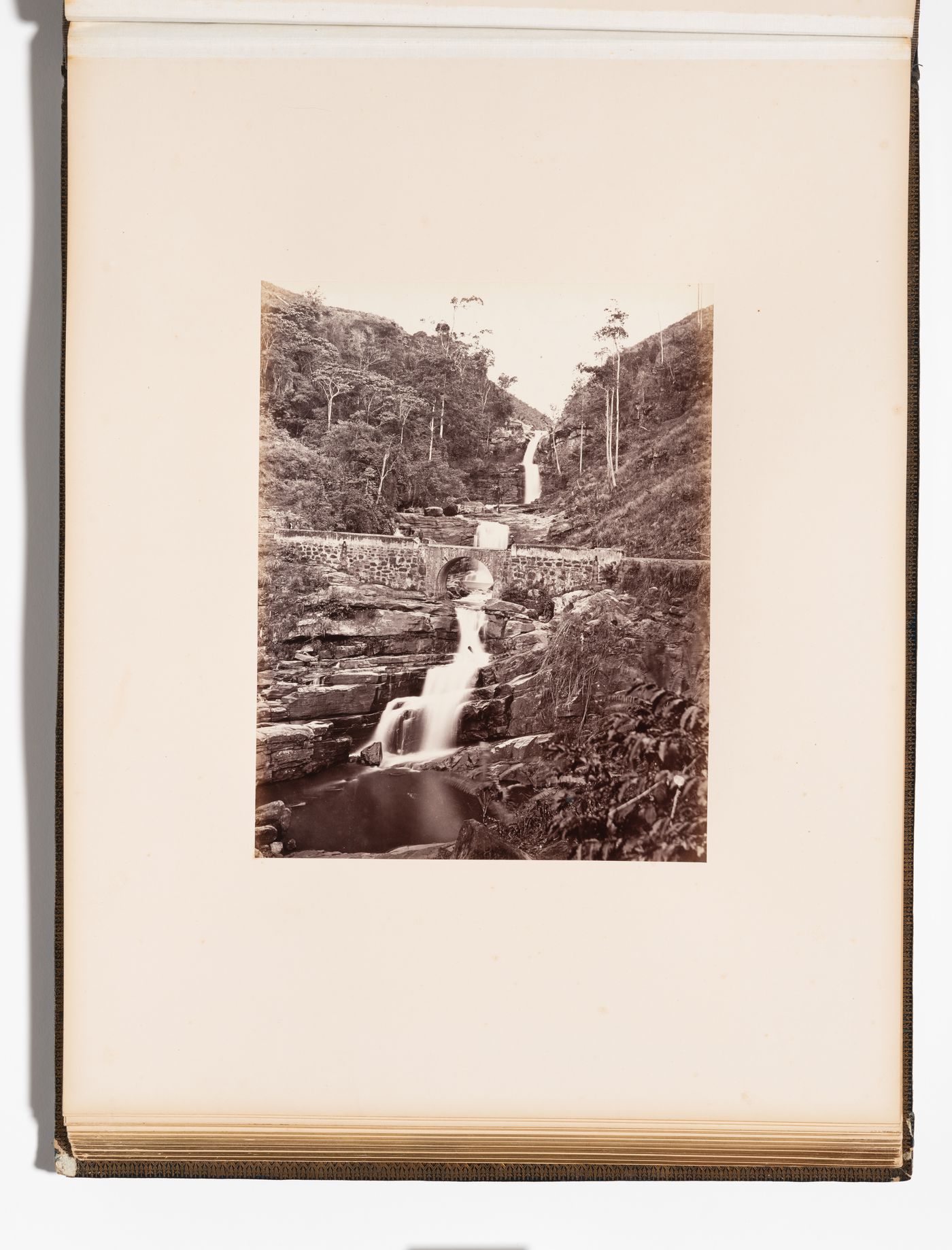 View of a bridge and the Kadialena Falls (also known as Kadiyenaléna Falls), Kotinalu [?], Ceylon (now Sri Lanka)