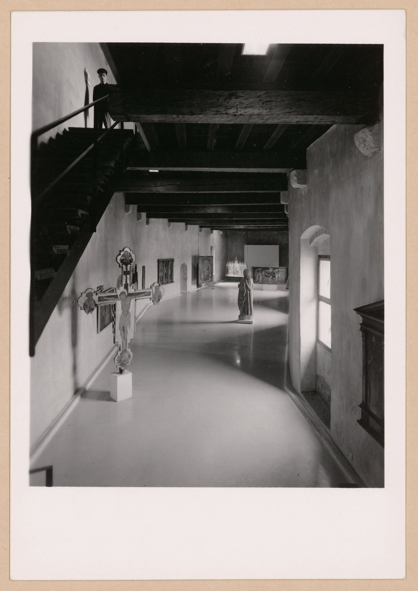 Interior view of a gallery showing a freestanding painted crucifix, a statue and paintings, Museo di Castelvecchio, Verona, Italy