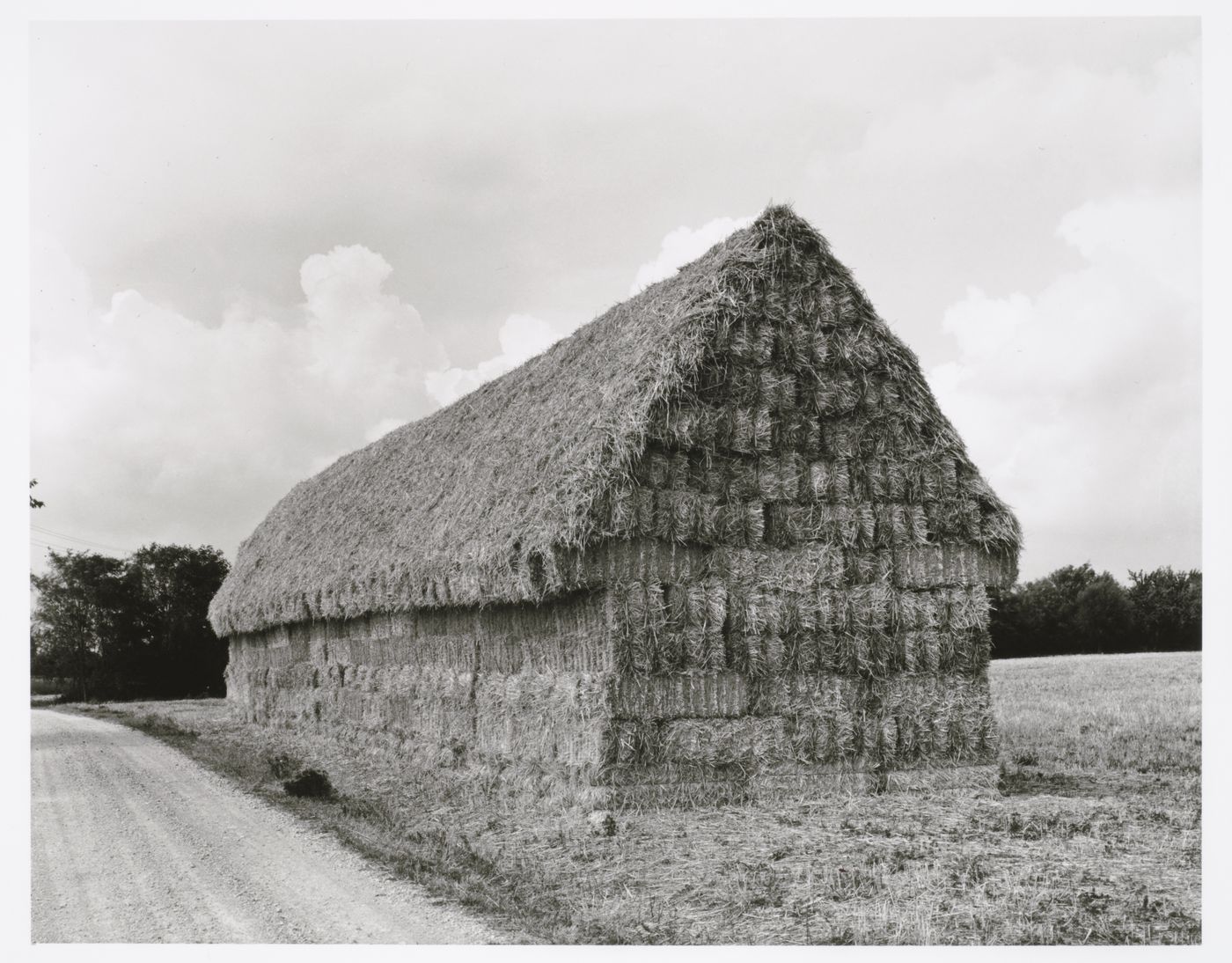 View of bales of straw stacked in the shape of a house, Toscana, Italy