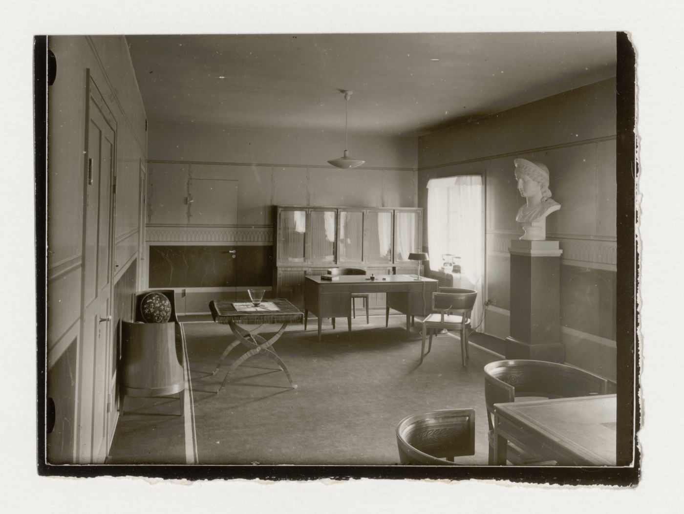 Interior view of the director's office of Stockholm Public Library showing tables, chairs and a sculpted bust, 51-55 Odengatan, Stockholm